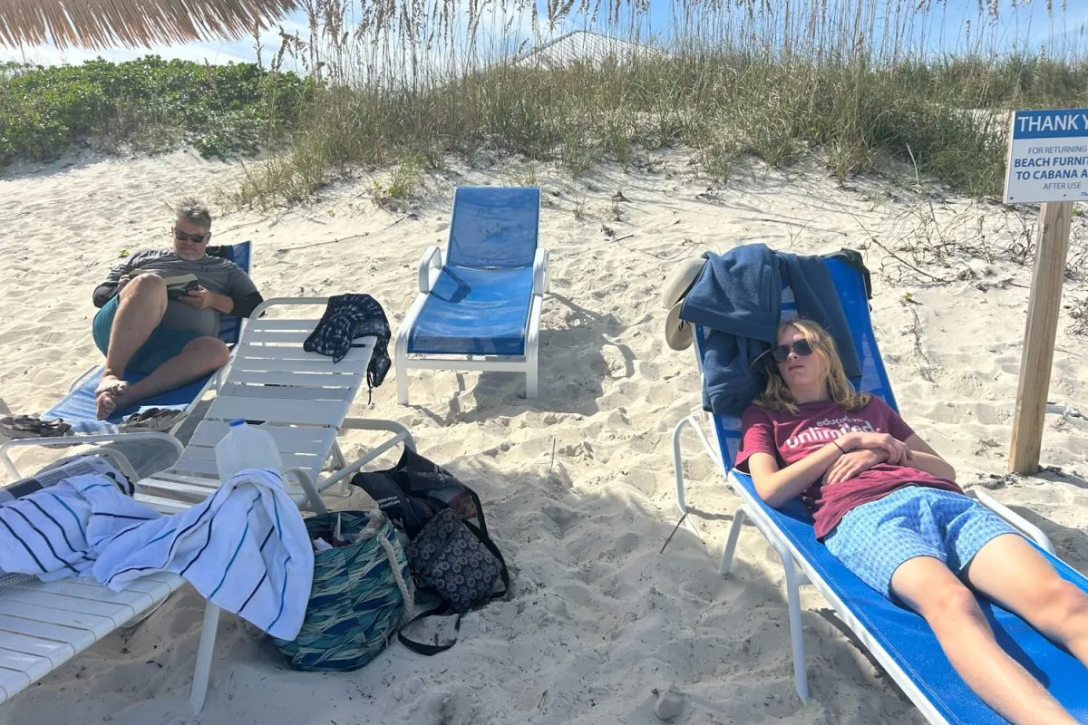 two men relaxing in beach loungers